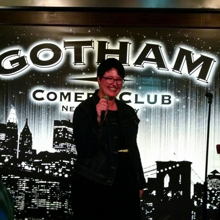 Violet smiling with a microphone at Gotham Comedy Club