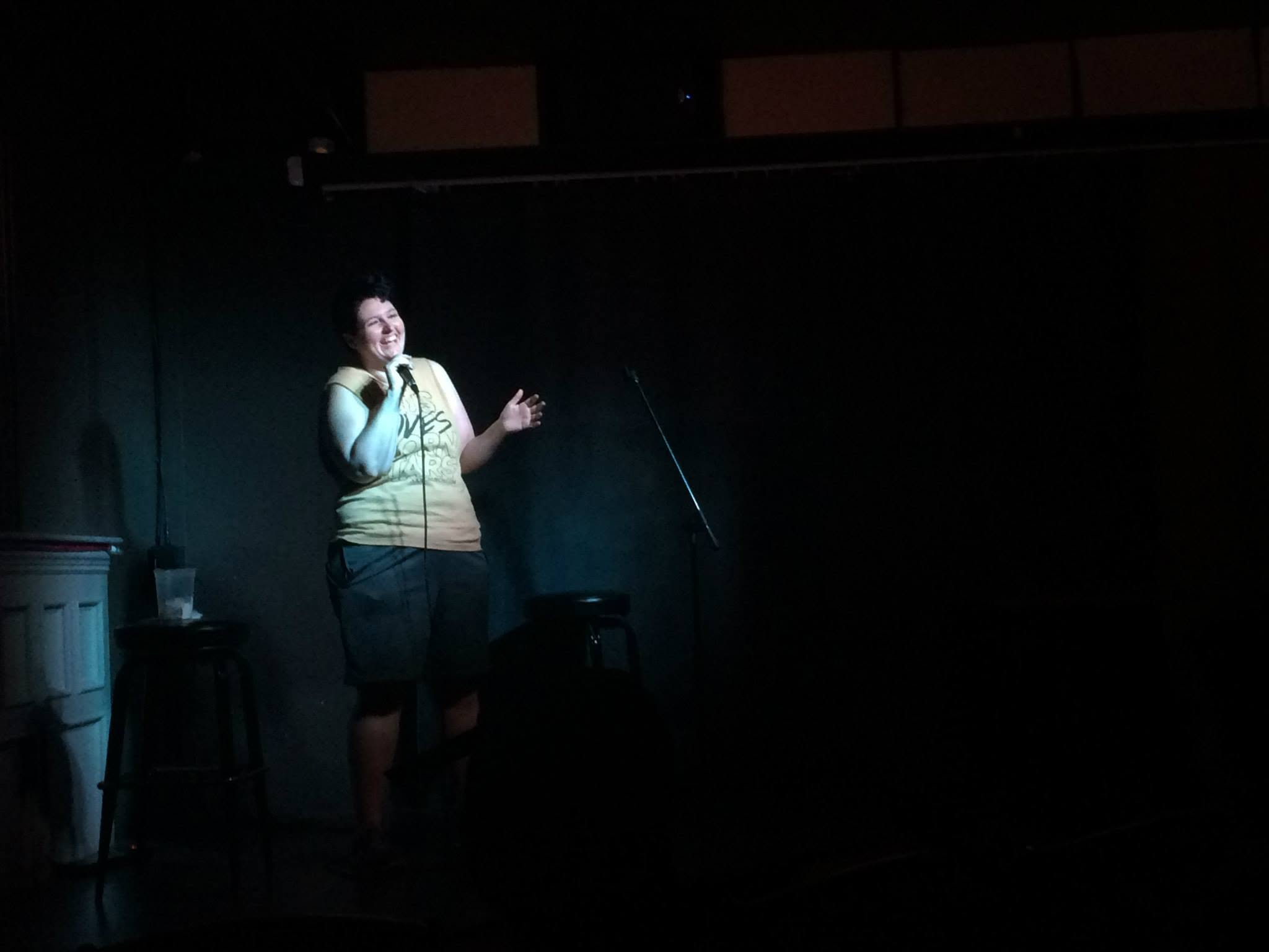 Violet performing stand-up in a pool of stage light